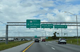 SR 417 commences northbound along a collector distributor roadway through the directional cloverleaf interchange joining Interstate 4 with World Drive at Celebration.