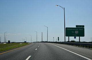 Curving southward across Osceola Parkway, the subsequent exit for the GreeneWay lies one mile ahead with Celebration Avenue.