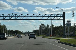 Heading away from CR 54 (Wesley Chapel Boulevard), Bruce B. Downs Boulevard starts with six overall lanes. The first marker for SR 581 stands next to the Village Market shopping center just south of Wesley Chapel Boulevard.