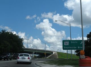 A ground level guide sign directed the continuation of SR 115 south from Arlington Expressway to Southside Boulevard.