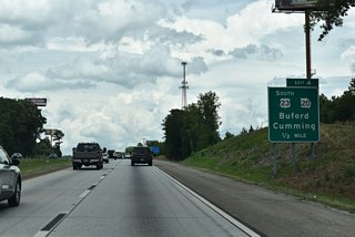 SR 20 arcs south from Exit 4 along a heavily developed commercial arterial to the Mall of Georgia and the SR 316 freeway. The state route leads south from Buford to Lawrenceville and northwest to Cumming.