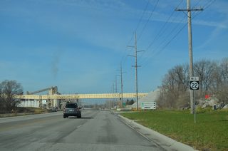 An asphalt plant and mining operations line Iowa 22 (Front Street) at the Linwood section of Buffalo. This reassurance marker stands beyond 115th Avenue.