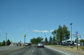 Business Loop I-84/SH 19 (American Legion Boulevard) curve northeast along a commercialized strip to the diamond interchange where U.S. 20 branches east from I-84/U.S. 26-30 to Hill City and Fairfield.