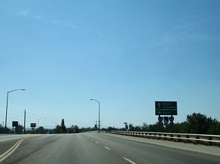 Passing over I-84, Centennial Way reaches the eastbound entrance ramp for I-84/U.S. 20-26-30 to Boise.