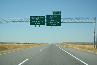 The I-86 westbound mainline defaults onto I-84 west while Exit 1 loops onto I-84 east in one mile. The freeway travels on a southeast trajectory into Utah where it joins I-15 at Tremonton. I-15/84 overlap to Ogden, where I-84 heads southeast to I-80 at Echo Junction and I-15 continues southward into Salt Lake.