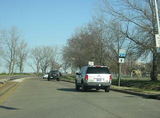Veterans Memorial Parkway turns toward the north as another sign directs travelers on the Ohio River Scenic Byway to stay on the parkway through the heart of Downtown Evansville.