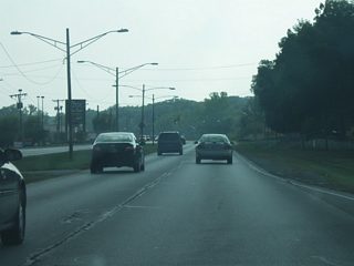 Southwest of Covington Road, Jefferson Boulevard begins to transition into a suburban highway as it gains a grassy median and passes by more shopping centers en route toward the interchange with Interstate 69/U.S. 33.