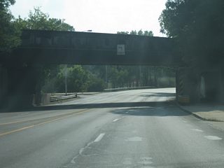 Jefferson Boulevard passes underneath a railroad overpass as left turns are prohibited along this tight and congested stretch of highway.