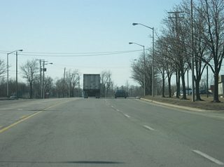 Washington Boulevard begins west of the interchange with SR 930 north/Coliseum Boulevard. The first part of the highway carries both directions of the former route of U.S. 24, U.S. 30 and SR 14. In the second picture, the roadways split as the westbound lanes continue along Washington Boulevard while the eastbound lanes follow Maumee Avenue. A Fort Wayne gateway greets motorists along westbound Washington Boulevard in the second picture.