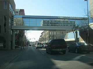 Washington Boulevard passes underneath a skybridge as it approaches the next intersection with Calhoun Street. The skybridge connects One Summit Square with a parking garage.