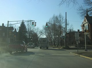 West of Broadway Street, Washington Boulevard becomes a residential two-way street even as it remains heavy with traffic. Since Interstate 69 was routed to the west of Fort Wayne, streets such as Washington and Jefferson Boulevards still carry heavy commuter traffic out of Downtown each weekday. In the second picture, Washington Boulevard crosses the intersection with College Street.