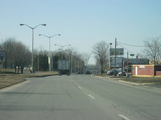 Washington Boulevard begins west of the interchange with SR 930 north/Coliseum Boulevard. The first part of the highway carries both directions of the former route of U.S. 24, U.S. 30 and SR 14. In the second picture, the roadways split as the westbound lanes continue along Washington Boulevard while the eastbound lanes follow Maumee Avenue. A Fort Wayne gateway greets motorists along westbound Washington Boulevard in the second picture.