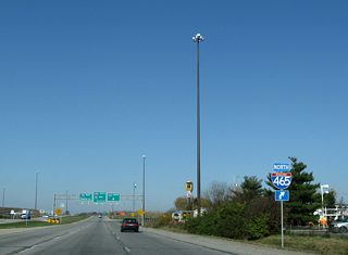 Crawfordsville Road directly upgraded into the I-74 freeway west of U.S. 136 and High School Road. A cloverleaf interchange with Interstate 465 followed.