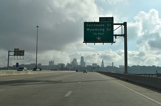 Interstate 670 (Dillingham Freeway) elevates across the Kansas River and two Union Pacific Railroad lines to the split diamond interchange (Exit 1B) with Genessee and Wyoming Streets.