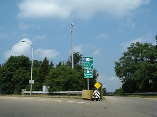 Former paddle signs posted at the Furnace Brook Rotary ramp to a service road leading to both I-93 and Willard Street north.
These signs were replaced by 2012. The flashing beacon was also removed previously and all vegetation cut back.
