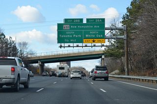 Just east of the directional cloverleaf interchange (Exit 28) with MD 650 (New Hampshire Avenue) on I-495 west. New Hampshire Avenue stems north from Washington, D.C. through Takoma Park to Langley Park and the Capital Beltway at Hillandale.