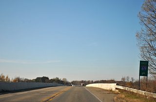 The Francis Road loop ramp onto the I-96 east to I-69 east connector departs for Flint. Ahead Francis Road ends at Business Loop I-96 (Grand River Avenue), which ends nearby to the west.