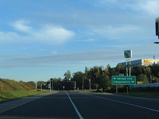 Exit 60 expands to three lanes ahead of Route 12 east and Truman Road. 12th Street spurs west from nearby to the Blue Valley Industrial area.
