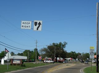 Angling northeast, MS 26 converges with Old Highway 63 along a commercial strip.