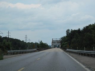 A cantilevered Warren through truss bridge carries traffic along Mississippi 26 over the Pascagoula River.