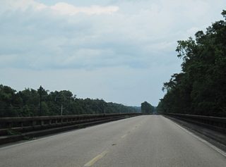Located north of the Riverview Estates community, the MS 26 Pascagoula River bridge extends east over wetland areas north of Hutson Lake.