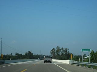 U.S. 90 proceeds northeast from MS 604 through Pearlington across Cowan Bayou.