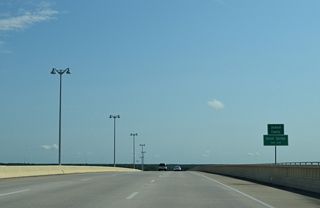 The navigation channel along Biloxi Bay represents the Jackson County line. U.S. 90 enters the city of Ocean Springs east at the bridge crest as well.