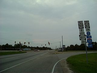 U.S. 90 previously intersected MS 63 north and MS 611 (Industrial Road) south at a signalized intersection adjacent to an at-grade CSX Railroad crossing. Construction finished in 2014 built a flyover for MS 63/611 and connecting ramps with U.S. 90.