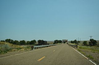 Old Highway 10 and the parallel BNSF Railroad both span the Powder River over Warren through truss bridges.
