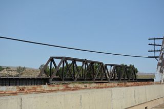 The adjacent BNSF Railway bridge across the Powder River was originally built in 1921. The outer deck girders were added in 1925 (Baughn, 2021).