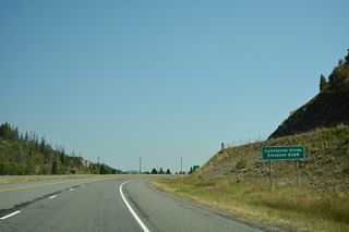 Interstate 15 travels across the Continental Divide east of Rampart Mountain and north of Woodville Canyon.