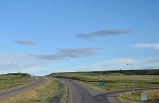 Interstate 15 commences south from the U.S. Customs Station at a folded diamond interchange (Exit 397) with S-214 at 2nd Street and 3rd Avenue in Sweet Grass.