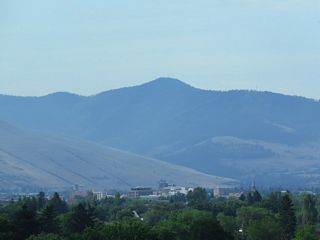 The spire of the Missoula County Courthouse appears to the southeast of Interstate 90. Mount Dean Stone abuts southern reaches of the street grid at an elevation of 6,204 feet.
