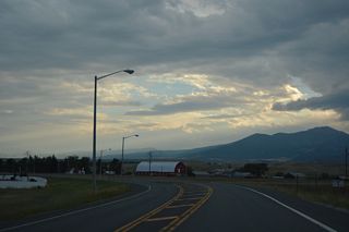 Main Street curves south and becomes part of Old U.S. 10 beyond N Frontage Road. Deer Lodge Mountain lines the western horizon.