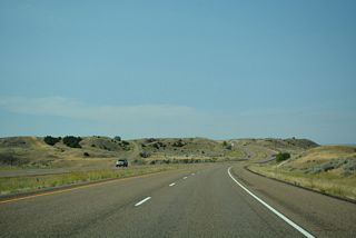 The old alignment of U.S. 10 reemerges from Interstate 94 to the south beyond mile marker 154 at Deep Creek.