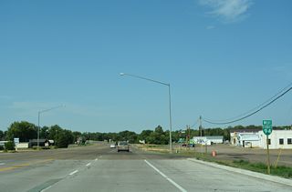 West from Montana Highway 16, Business Loop I-94 (Towne Street) passes north of West Plaza Shopping Center by this confirming marker.