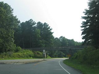 Resuming a westward course, NC 24/27 leave NC 109 and pass under a Aberdeen, Carolina & Western Railway line.