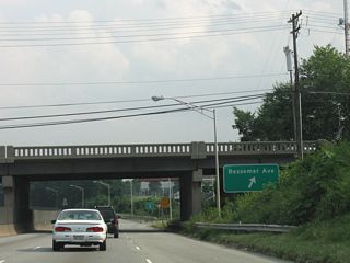 U.S. 70/220 join U.S. 29 (O&apos;Henry Boulevard) ahead of the RIRO ramps with Headquarters Drive to Bessemer Avenue. Bessemer Avenue parallels Wendover Avenue through a large warehouse district.