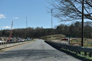 Navigating southeast through a broad S-curve, U.S. 74 crosses Buffalo Creek along a pair of vintage spans (1957 eastbound, 1922 westbound).