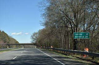 Main Street (SR 1167) spans U.S. 74 beyond this distance sign for Shelby and Gastonia.
