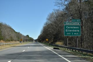 Ellenboro Henrietta Road (SR 1920) meets U.S. 74 1.6 miles east of Webbs Creek. The forthcoming Exit 187 connects the freeway with the town of Ellenboro and unincorporated Henrietta. An abandoned CSX Railroad line passes over the freeway ahead.