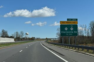 Curving southeast across Hickory Creek, the Shelby Bypass advances to a dogbone interchange (Exit 203) with NC 150 (Cherryville Road).