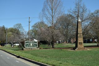 U.S. 74 shifts north along King Street by a welcome sign and monument for Kings Mountain.