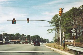 NC 168 (Caratoke Highway) northbound at NC 34 (Shawboro Road) south in Sligo. NC 168 constitutes a five lane arterial northwest from Barco to Chesapeake, Virginia. NC 34 leads three miles south to Shawboro.