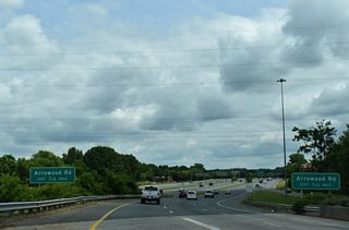 A high flyover links I-485 east with a c/d roadway along I-77/U.S. 21 north to Arrowood Road (SR 1138).