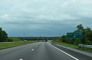 Black Creek Road (SR 1606) extends 2.81 miles south from Pender Street and the Wilson street grid to a parclo interchange (Exit 26) with I-587/U.S. 264.