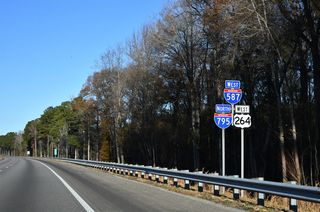 These confirming markers for I-587 west, I-795 north and U.S. 264 west precede the Quaker Road (SR 1162) over crossing.