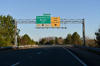 I-795 combines with I-587/U.S. 264 westbound 0.52 miles ahead of the folded diamond interchange (Exit 22) with Downing Street (SR 1163).