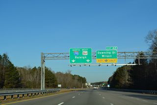 Succeeding lane drops precede Exit 22 for Downing Street (SR 1163) east into Wilson.