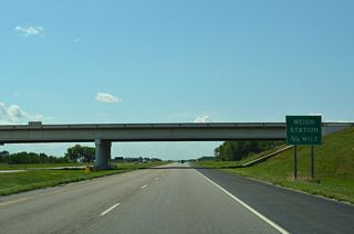 A truck weigh station operates along Interstate 94 westbound 0.75 miles beyond the 38th Street NW over crossing.